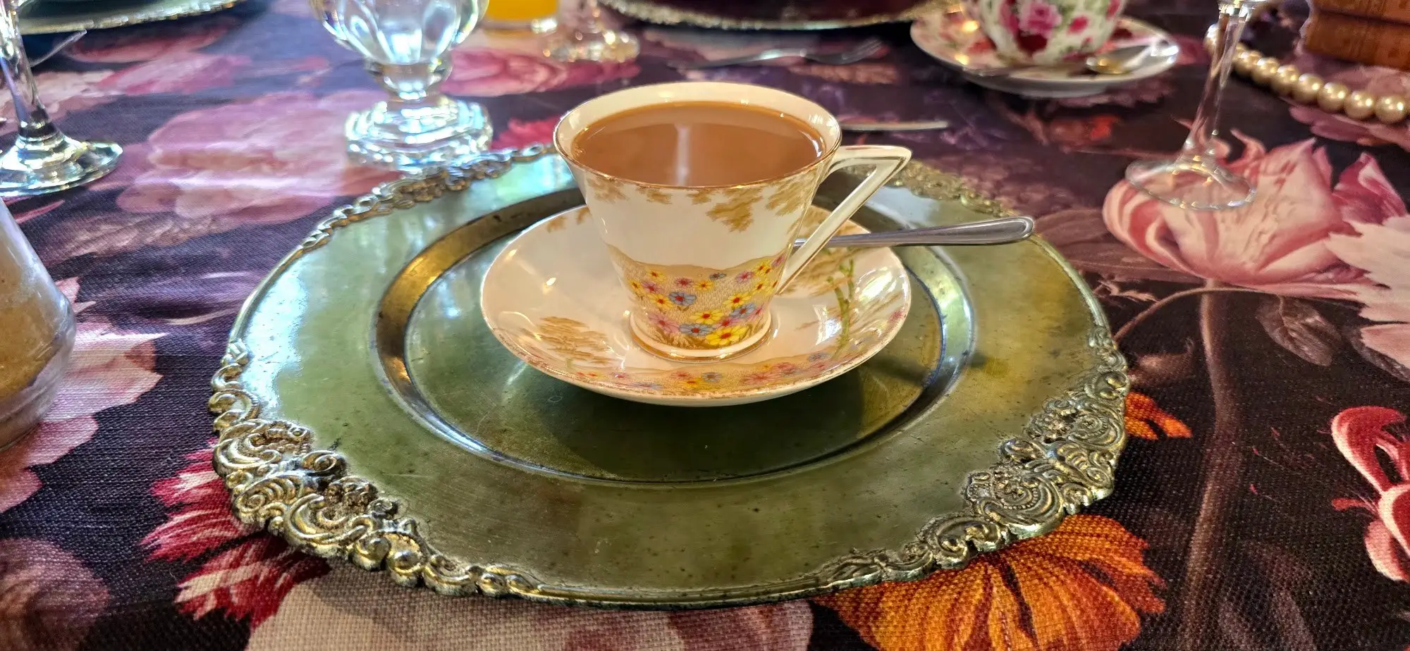 A vintage tea cup on a gold charger